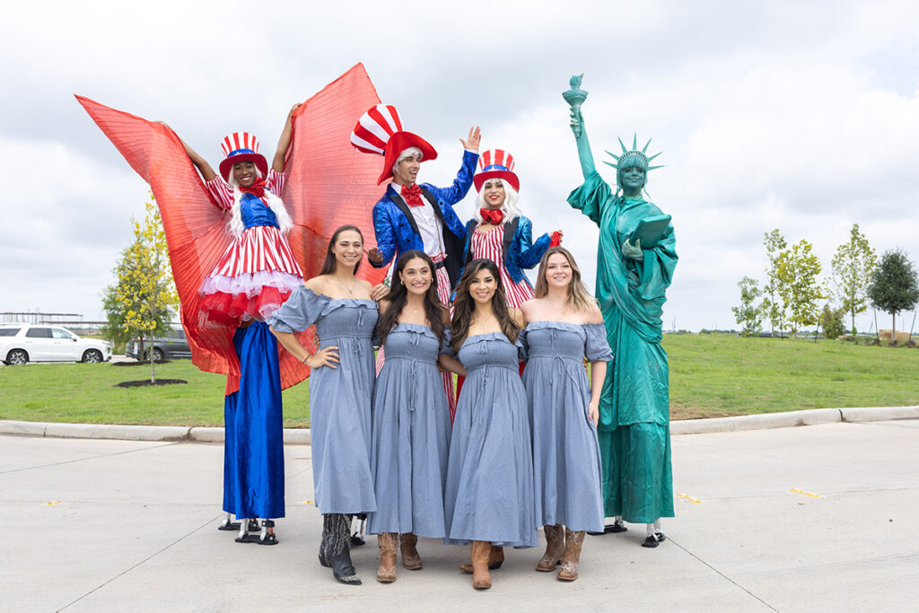 Five women in blue dresses pose near Richmond TX in a Brookewater event.