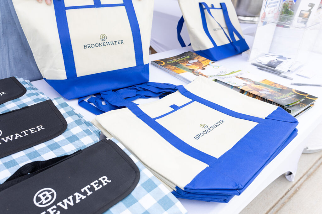 Blue and white Brookewater tote bags for new home builders near Richmond TX on display.