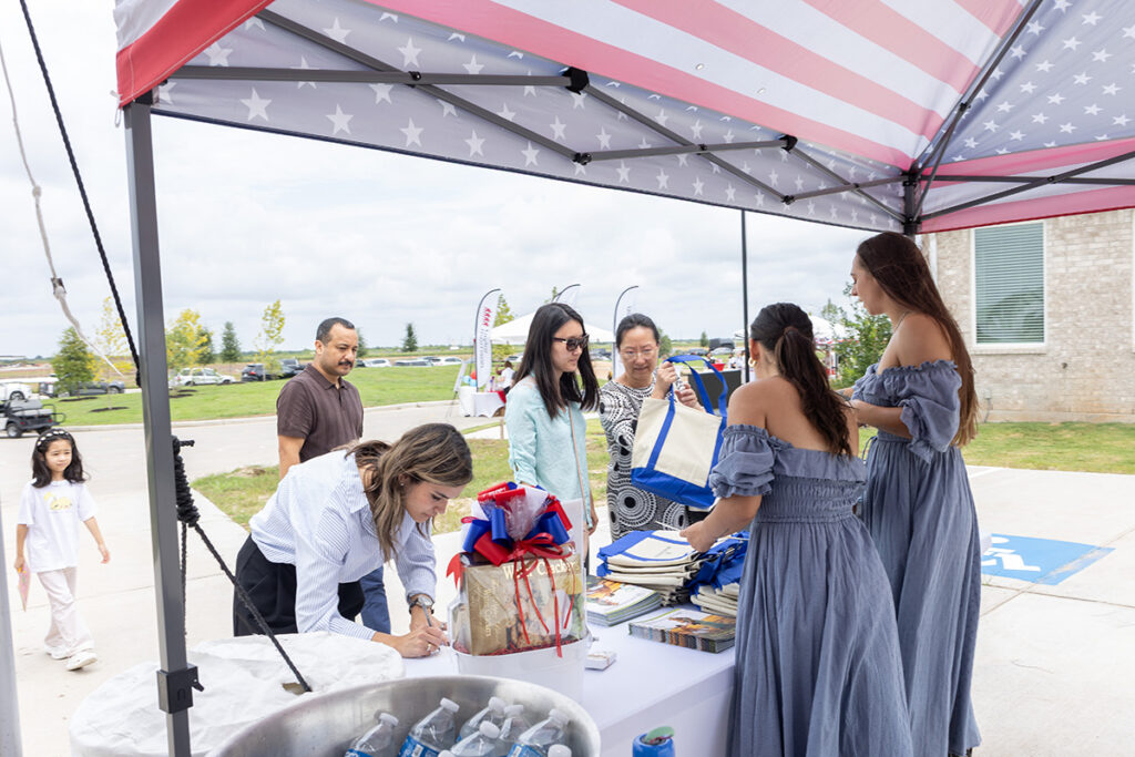 People gather under a tent with American flag theme in a Brookewater event near Richmond TX.