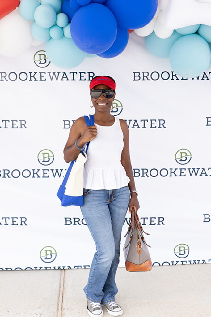 Woman in casual outfit poses near Richmond TX in front of a BrookeWater master-planned community backdrop.