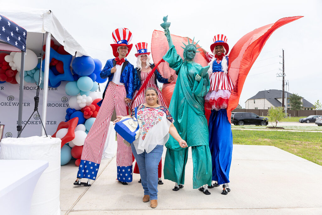 A woman poses with Statue of Liberty and Uncle Sam at a Brookewater event near Richmond, TX.