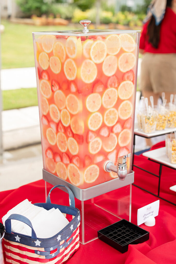 Large beverage dispenser with lemons, on a red tablecloth near Richmond TX.