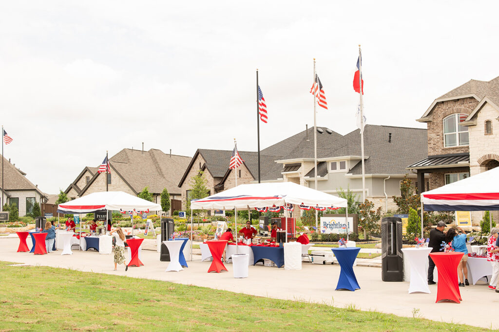 Outdoor event with festive tents and flags in the Brookewater master-planned community.