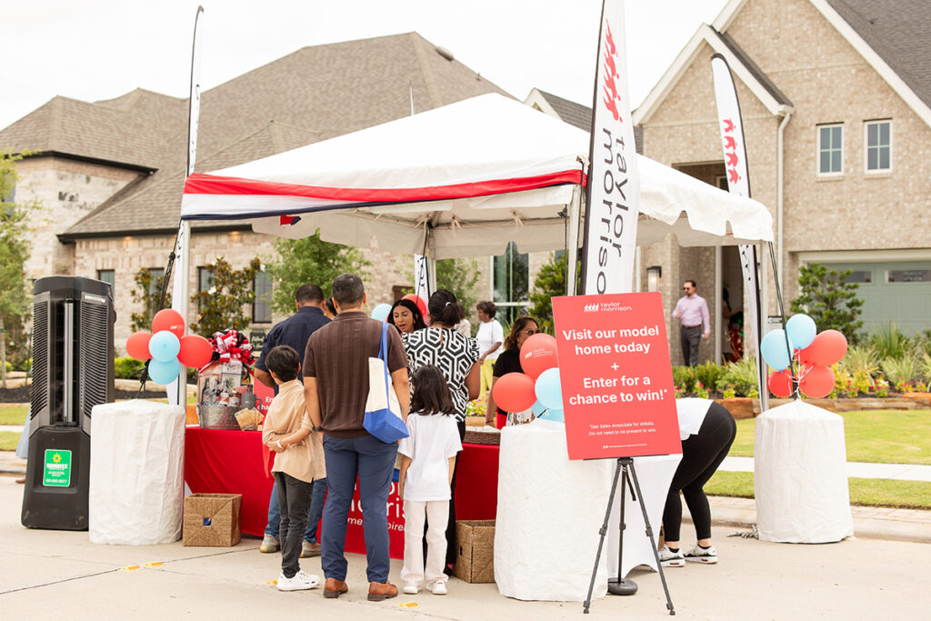 People gather at an outdoor booth near Richmond TX promoting at Brookewater master-planned community tour.