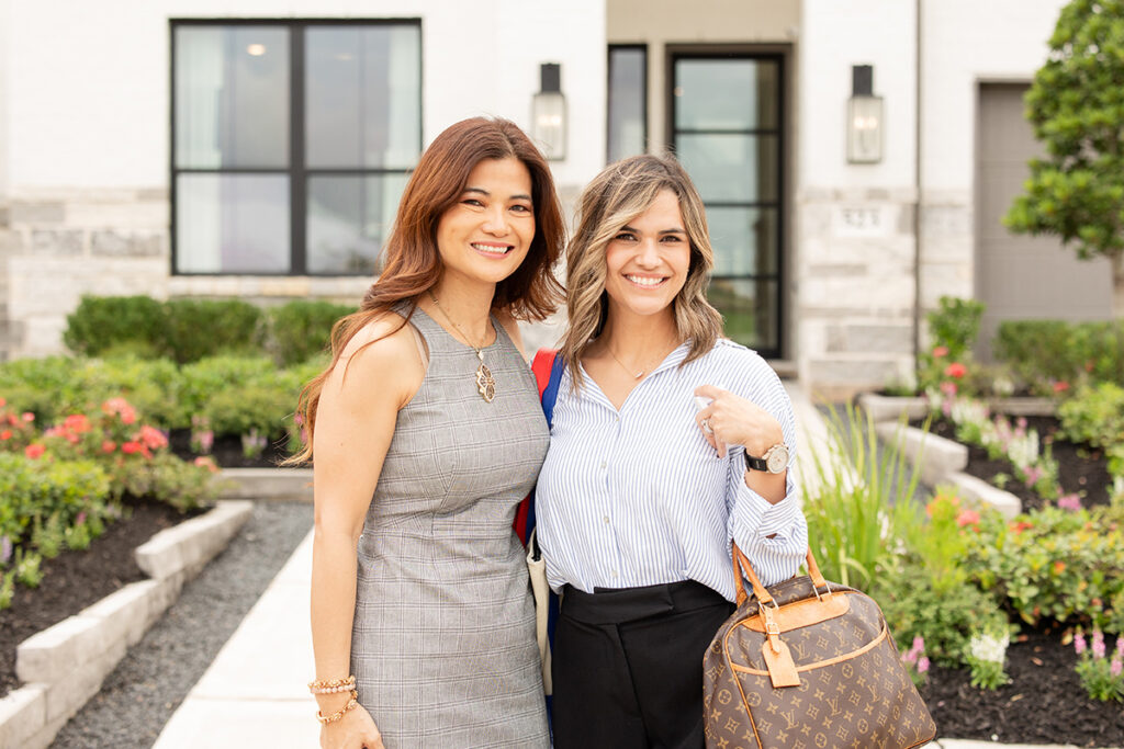Two women smiling outside a modern home in a vibrant master-planned community Brookewater.