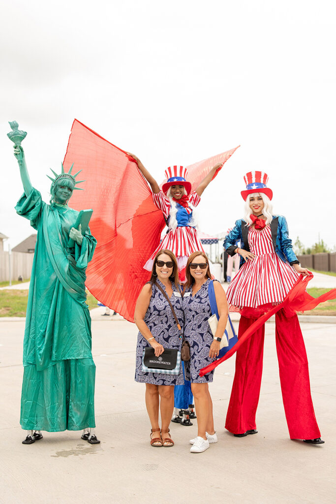 Two women pose with Statue of Liberty and Uncle Sam at Brookewater new homes for sale event.