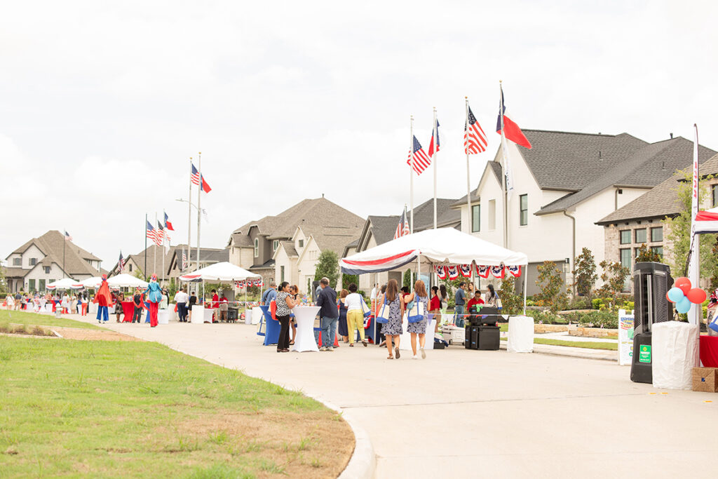 People gather at tents in Brookewater, a master-planned community near Richmond TX.