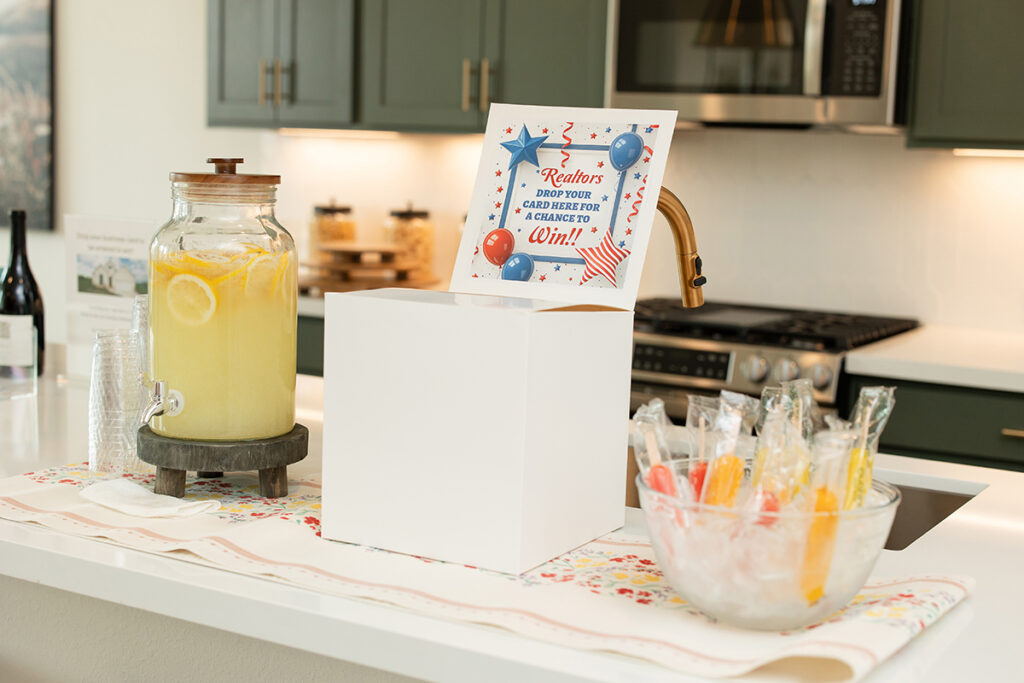 A kitchen counter in Brookewater with a lemonade dispenser, popsicles, and a raffle entry box.
