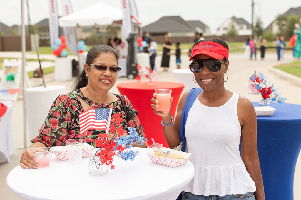 Two women enjoy drinks and snacks at a Brookewater community event near Richmond, TX.