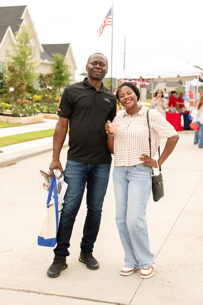 Two people smiling at a Brookewater event, holding a bag and papers in a master-planned community.