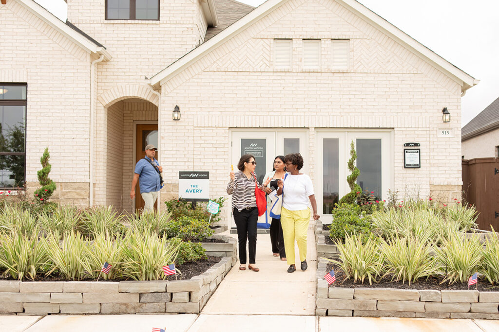 Four people chat outside a Brookewater home by new home builders near Richmond TX.