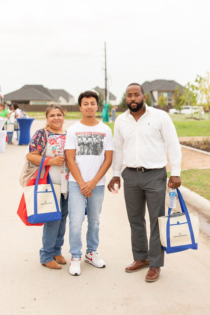 Three people with tote bags at Brookewater, a community by new home builders near Richmond TX.