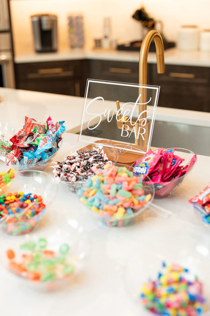 Bowls of colorful candy sit by a Sweets Bar sign in the Brookewater master-planned community.