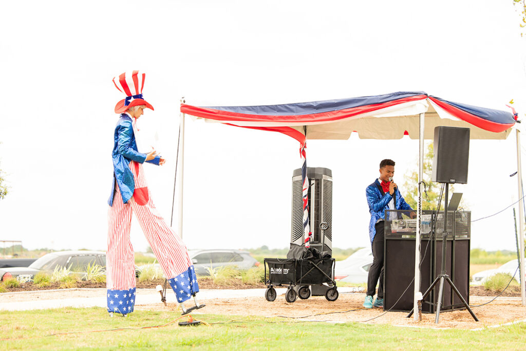 Person on stilts in patriotic costume entertains at Brookewater master-planned community outdoor event.