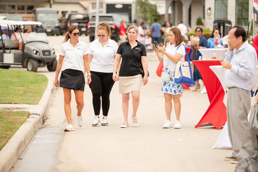 A group gathers on a paved path at an outdoor event in the Brookewater master-planned community.