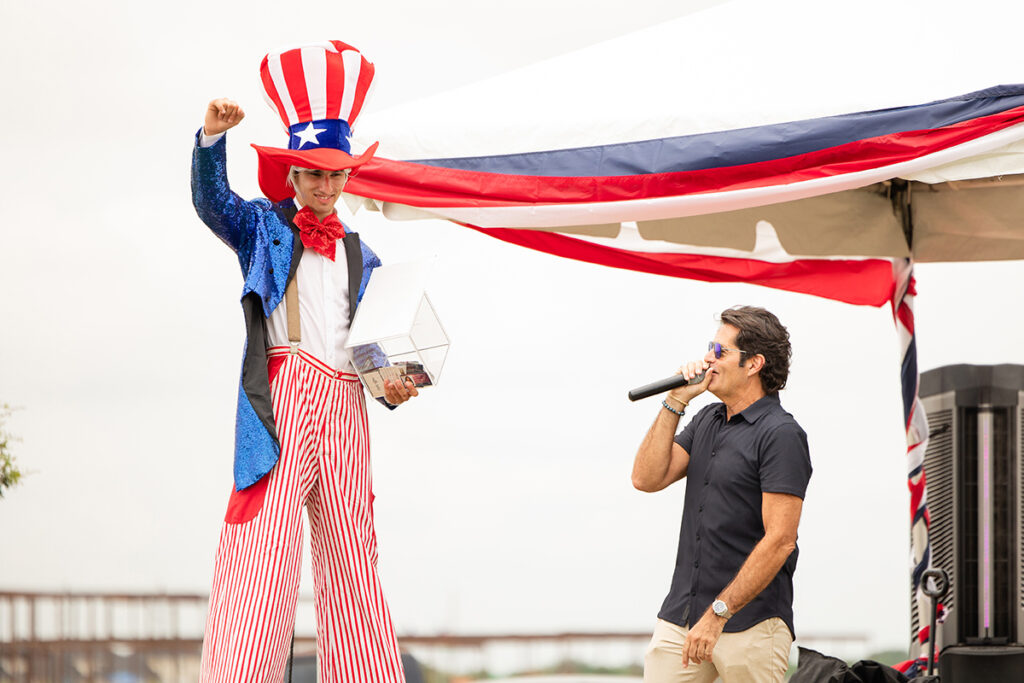 A man in an Uncle Sam costume stands beside a speaker near Richmond TX Brookewater outdoor event.
