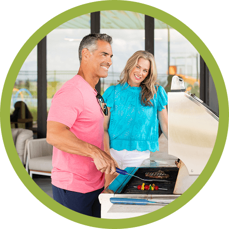 Man grills outdoors near Richmond TX, smiling in a master-planned community setting.