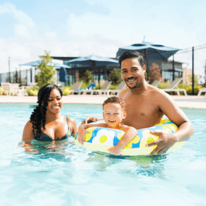 Two adults and a child enjoy Brookewater’s sunny pool, near Richmond TX.