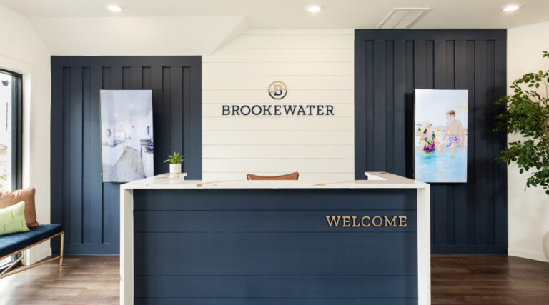 Reception desk at Brooke Water office with “Welcome” sign and two photos on the wall.