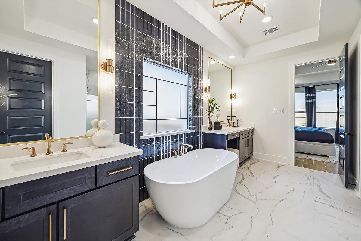 Modern bathroom with a freestanding tub, double vanity, and marble flooring.